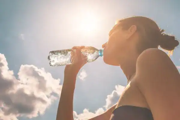 Hydration: The Secret Ingredient for a Toned Stomach and Enhanced Fitness 3 Image of woman drinking water to hydrate Brentwood after run.